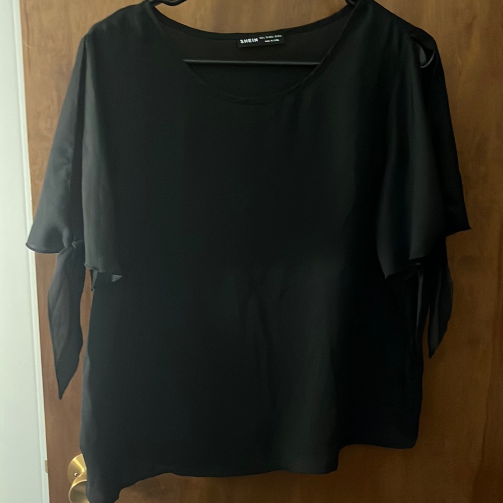 black blouse with cut out shoulders and tied sleeves